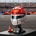 A red and white Ferrari racing helmet model on a black display stand, with a small brick-built driver figure in front. The helmet features visible sponsor decals including Visa Credit, HP, Shell, and VistJet, and a yellow Ferrari prancing horse logo.