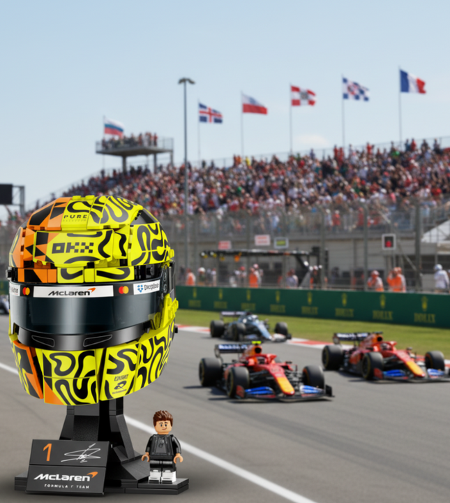 A building-block style racing helmet display on a black stand, featuring a neon yellow and black patterned helmet with orange accents, a dark visor, and visible McLaren and Dropbox branding. A small driver minifigure stands beside the stand on a branded plaque.
