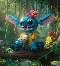 A colorful toy building-block character resembling Stitch, with large blue and pink ears, a pink flower headpiece, yellow clothing, and an ice cream cone accessory, shown on a plain white background.