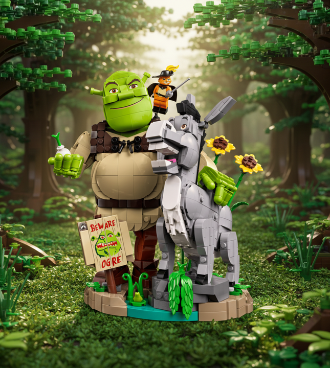 A building block set depicting Shrek and Donkey on a stylized base with flowers, green plants, and a sign reading 'Beware Ogre'.