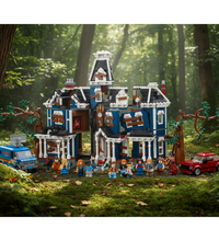 A large brick-built haunted house set with multiple mini-dollhouse details, surrounded by a blue van, a red car, and several small toy figures, shown on a plain white background.