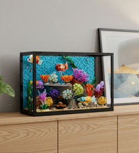 A underwater aquarium scene built with a black baseplate, featuring colorful coral, sea plants, fish, a crab, and a striped fish on a white background.