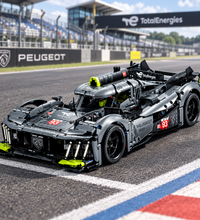 A gray and black building-block toy race car with visible Peugeot and Delphi branding, shown on a plain white background.