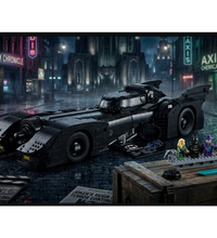 A black LEGO Batman vehicle set displayed on a rainy Gotham city street, with Batman and Robin minifigures beside a wooden crate in the foreground.