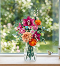 A colorful LEGO flower bouquet with pink, orange, peach, white, and blue flowers, green leaves, and white background.