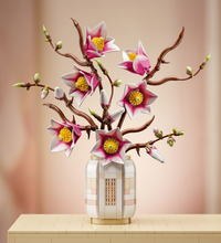 A decorative floral arrangement of artificial cherry blossom-style flowers on brown branches, isolated on a white background.
