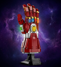 LEGO Infinity Nano Gauntlet toy building block set, featuring a red and gold gauntlet with the six colored gemstones, mounted on a black display stand with a LEGO logo plaque.