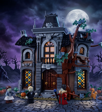 A haunted house building set with a gray stone facade, brown door and tree trunk, blue stained-glass windows, green foliage, and small minifigures and animals placed around the base on a white background.
