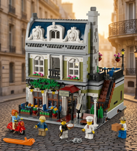 A detailed LEGO-style building set of a multi-story cafe building with small minifigures and accessories, shown on a plain white background.